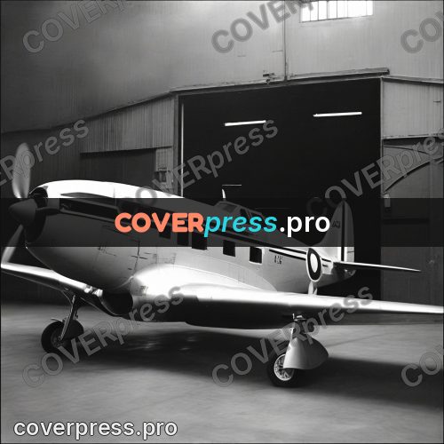 Black and white photo: aeroplane by the hangar doors