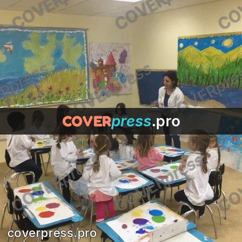 Wax crayon drawing: children at a table with paints